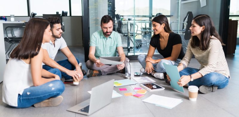 young-business-team-sitting-with-manager-floor-while-discussing-creative-office-meeting.jpg